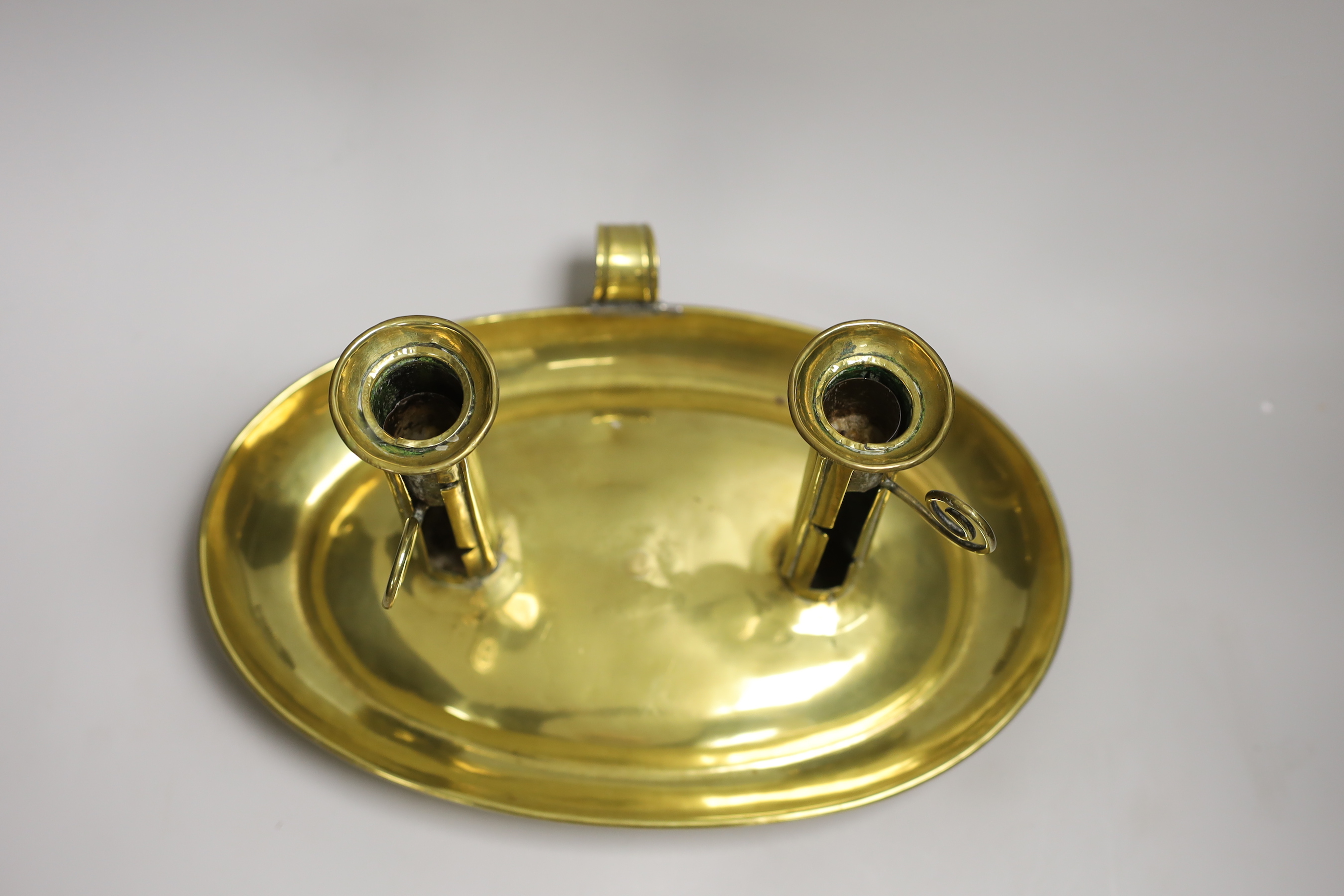 A large brass double chamber candlestick, English c.1800, with oval trap, 33cm wide